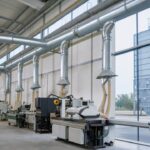 Réseau de dépoussiérage industriel avec gaines galvanisées et dépoussiéreur à manches dans une usine moderne